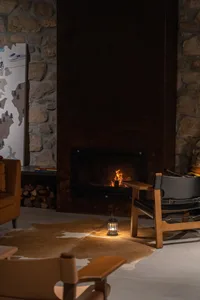 A cozy living room with a large stone fireplace and comfortable seating arrangements.