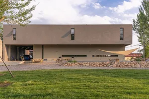 A modern residential building with a concrete exterior and large windows.