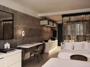 Modern bedroom with minimalist design, featuring a white bed, desk, and abstract wall textures.
