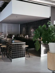 Modern interior of a restaurant bar with black and white tile accents and a minimalist design.