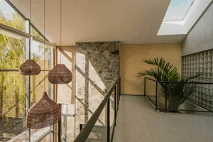 Modern entryway with stone walls and wooden beams, featuring a mix of natural and modern materials.