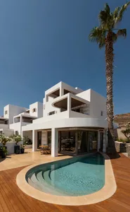 Modern, white-painted house with a swimming pool and concrete patio.