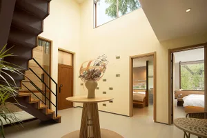 A modern interior space featuring a metallic staircase, natural light, and minimalist design.