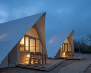 Two canvas glamping tents with walls and wooden planks