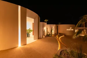 Concrete entrance pathway with warm lighting and minimalist design.