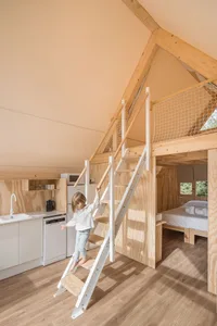 A minimalist interior design featuring wood materials and a ladder leading to a loft space.
