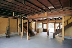 A spacious, modern interior with wooden floors and exposed wooden beams.