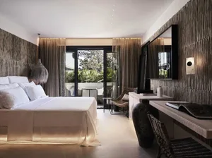 Modern minimalist bedroom featuring textured walls with a white bed and a balcony.