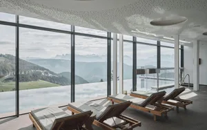 Modern pool deck featuring glass walls and concrete flooring.