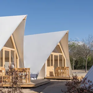 A modern residential tent with a white fabric roof on a wooden frame.