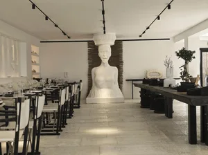 Modern restaurant interior featuring concrete flooring and mixed materials decor.