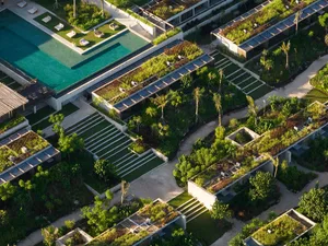 Aerial view of a residential area with green spaces, concrete pathways, and wooden structures