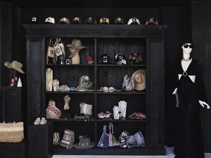 A wooden display case filled with various handbags and accessories.