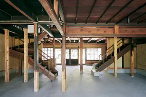 寬敞的商業室內空間，搭配木質結構元素與混凝土地板。