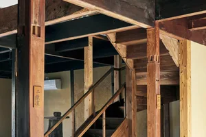 A photograph showcasing a staircase interior with wooden beams and supporting structures.