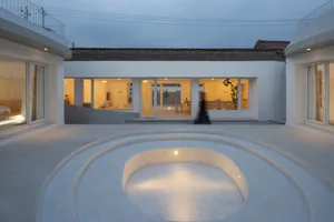 A modern house exterior with concrete walls and glass windows.