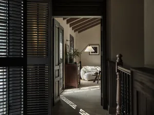 Modern industrial living room with wooden beams, white sofa, and floor lamp.