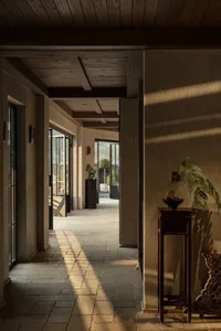 Modern minimalist corridor featuring stone and concrete materials and natural light.