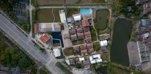 Aerial view of a modern residential development featuring well-maintained buildings, open green spaces, and a large body of w