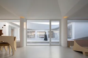 A modern residential interior with glass windows, featuring a minimalist aesthetic and natural light.