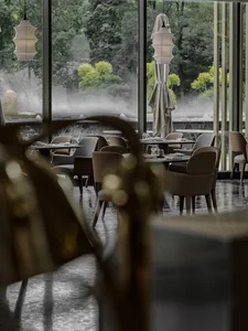 A modern restaurant interior with tables, chairs, and decorative elements arranged in a dining setting.
