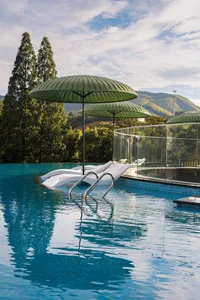 A modern swimming pool with glass walls and metal deck.