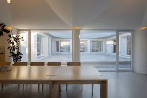 Modern white interior with clean lines, minimalist furniture, and a large open space.