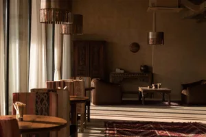 A cozy, rustic living room featuring wooden tables and plush cushions.