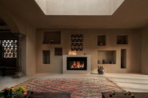 Minimalist living room with a concrete floor, fireplace, and built-in shelves.