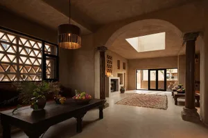 A spacious, modern interior living room with concrete and terracotta materials.