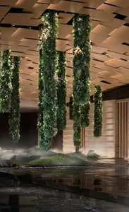 An indoor garden featuring vertical columns covered in lush greenery and moss.