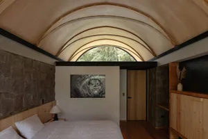 A minimalist bedroom with stone, wood, and glass elements