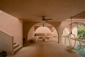Minimalist residential interior designed with concrete materials, featuring an arched ceiling and a rooftop swimming pool.