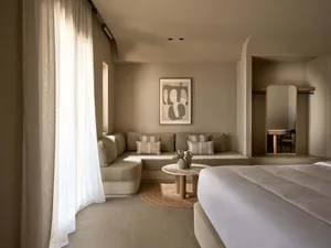 Modern bedroom with soft, neutral-toned furniture and minimalist decor.