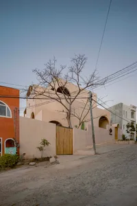 Modern building with earth-toned exterior materials, concrete base, and arched windows.