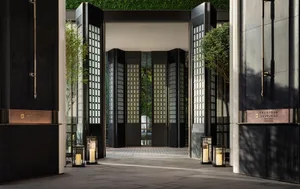 Modern hotel entryway featuring black glass and wooden panels