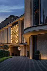 The grand entrance of a modern hotel, featuring granite walls and illuminated lighting.