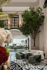 Luxurious hotel lobby with modern decor, concrete walls, glass walls, and greenery