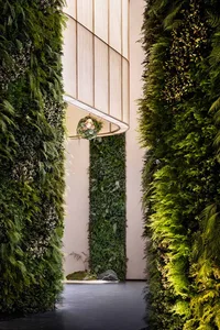 A modern interior living room featuring green plants on the walls.