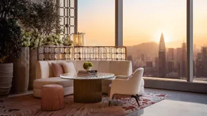 A modern living room with a city view at sunset.