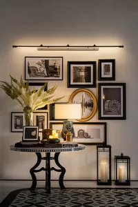 Modern living room with decorative objects in black, white, and gold colors, featuring a patterned floor and a wall collage o