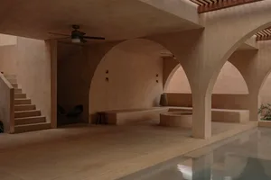 Minimalist architectural design featuring a concrete poolside with seating and a ceiling fan.