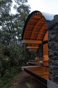 Modern outdoor living space featuring wooden construction and stone columns.