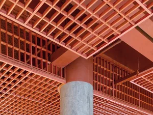 View of a modern architectural pavilion featuring a red grid pattern supported by a concrete column.