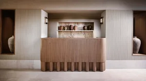 現代接待桌搭配木質牆板，內建展示架陳列陶瓷花瓶。