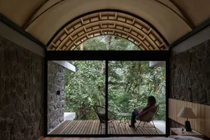 A modern residential interior with a view of the tropical jungle through large windows.