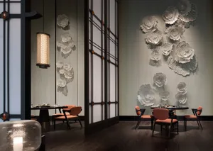 An elegant, modern restaurant interior featuring metallic floral wall art and dark wood flooring.