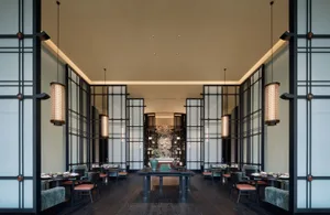 現代餐廳室內，鋪設深色木地板，搭配玻璃隔間與金屬框架椅。