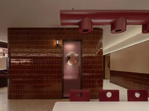 Modern restaurant interior with tiles and concrete walls painted in a red color scheme