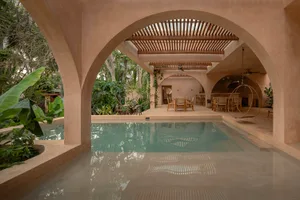 A modern residential interior featuring a terracotta pool house with a sleek, open-plan design.
